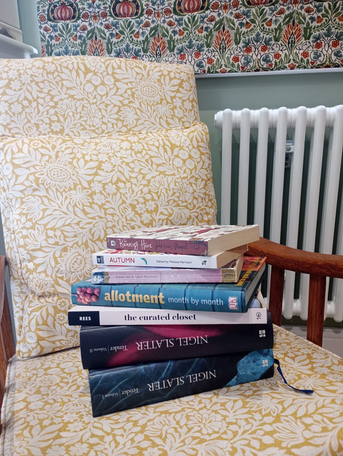 Photo of books to read stacked on armchair